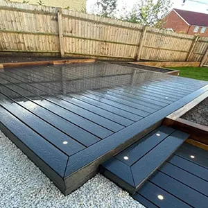 a backyard with a wooden deck and a fence