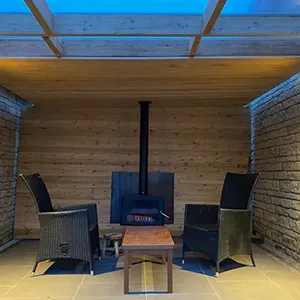 a living room with a wood stove and wicker chairs