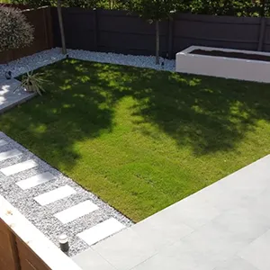 a backyard with a grass lawn and a wooden fence